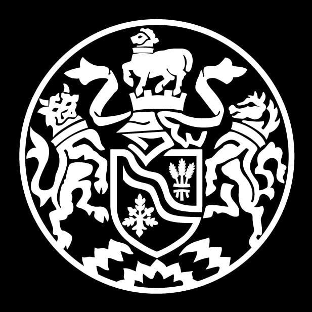 Black and white heraldic emblem featuring a horse above a shield with a snowflake and wheat, flanked by two stylized animals.